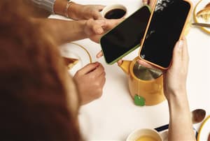People looking at their phones and enjoying tea