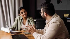 Two colleagues discussing work in an office. 