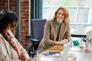 Two women sitting at a table in a conference room