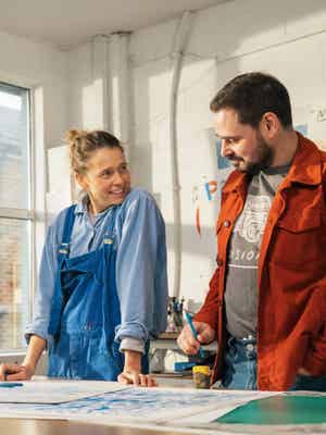 Woman and man standing in front of a desk in a workshop.