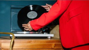A person placing a vinyl on their record player.